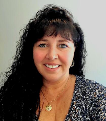 Smiling woman with dark hair and patterned top by IBEW 1837