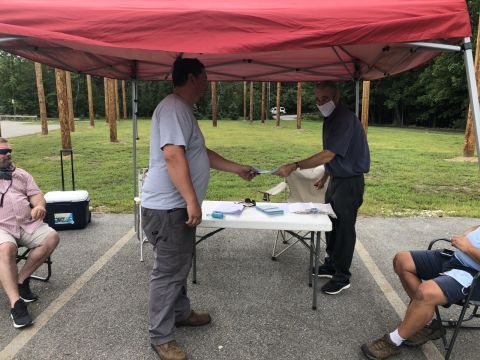 Man voting at a canopy table during Eversource vote by IBEW 1837
