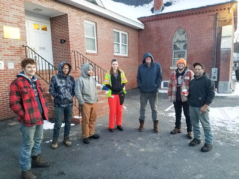 Six people standing outside a brick building in winter by IBEW 1837