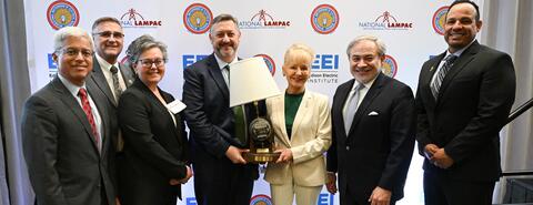 Group of officials posing with a lamp trophy at LAMPAC preview by IBEW 1837