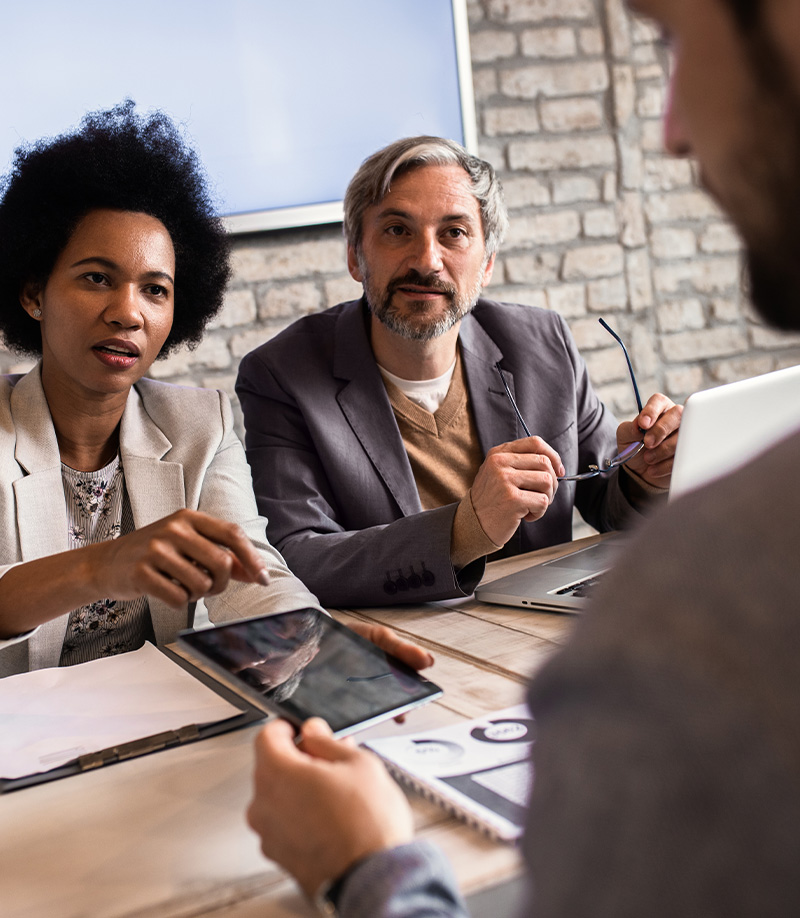 Financial advisors meeting with clients at a table by IBEW 1837