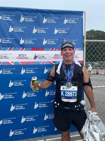 Marathon finisher holding a can and foil blanket by IBEW 1837