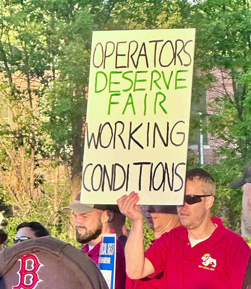 Union member holding a fair working conditions protest sign by IBEW 1837