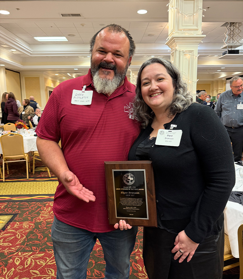 Two IBEW 1837 members holding an award plaque by IBEW 1837