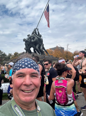 Smiling man with American flag bandana at marathon finish line by IBEW 1837