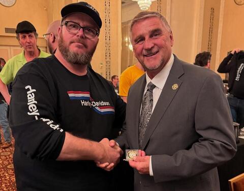 Two men shaking hands at an indoor event by IBEW 1837