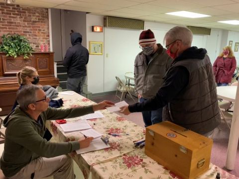 Union members casting ballots at contract vote table by IBEW 1837